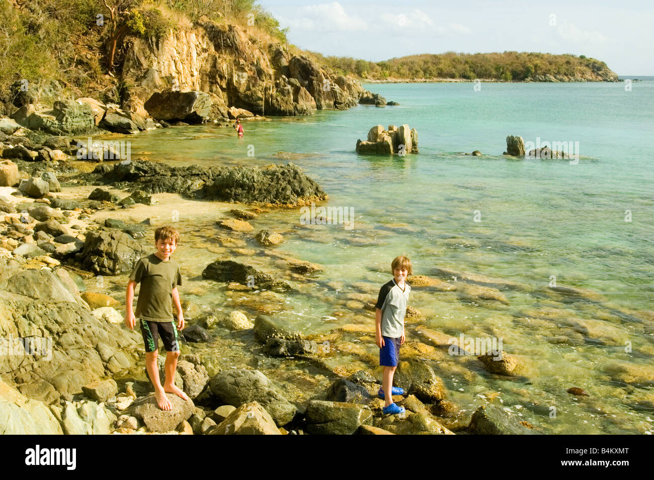 Jungs spielen auf den Felsen in der Nähe von Lamshur Bay Strand in St. John, USVI Stockfoto