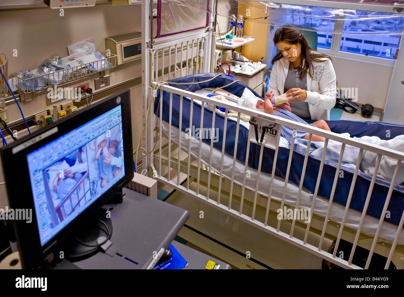 In einem Krankenhaus California pflegt eine Mutter ihren kleinen Sohn leiden spinal Bifida Hinweis Condition-monitoring-EEG Kappe Stockfoto