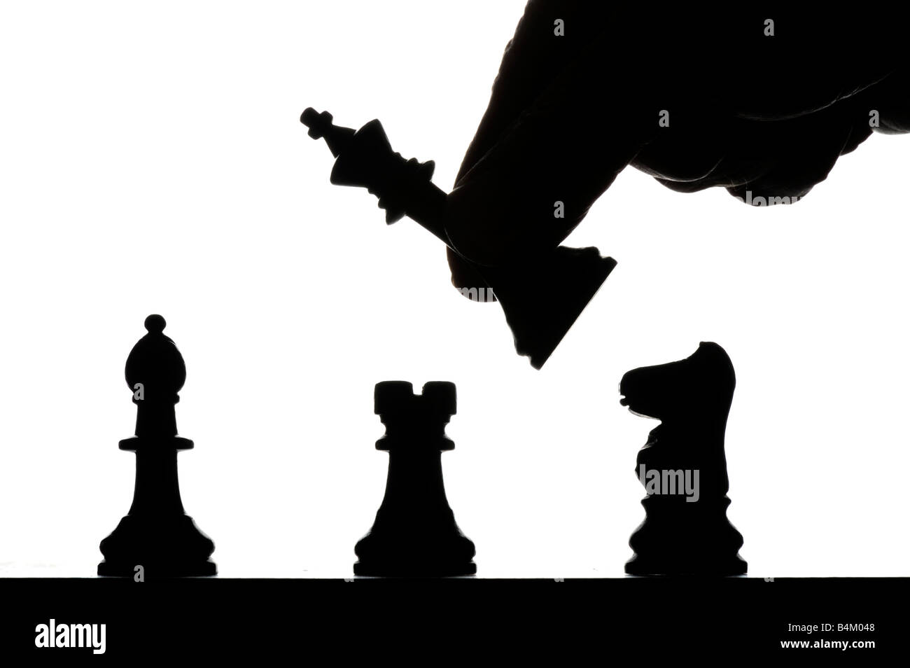 männliche Hand bewegt Silhouette auf Schachbrett Schachfiguren Stockfoto