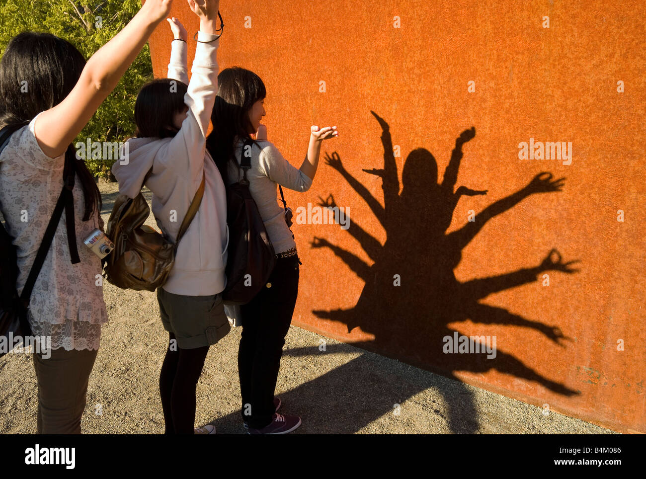 Japanische Mädchen Schatten spielen auf Skulptur in Seattle Art Museum Skulptur Garten Seattle Washington USA Stockfoto