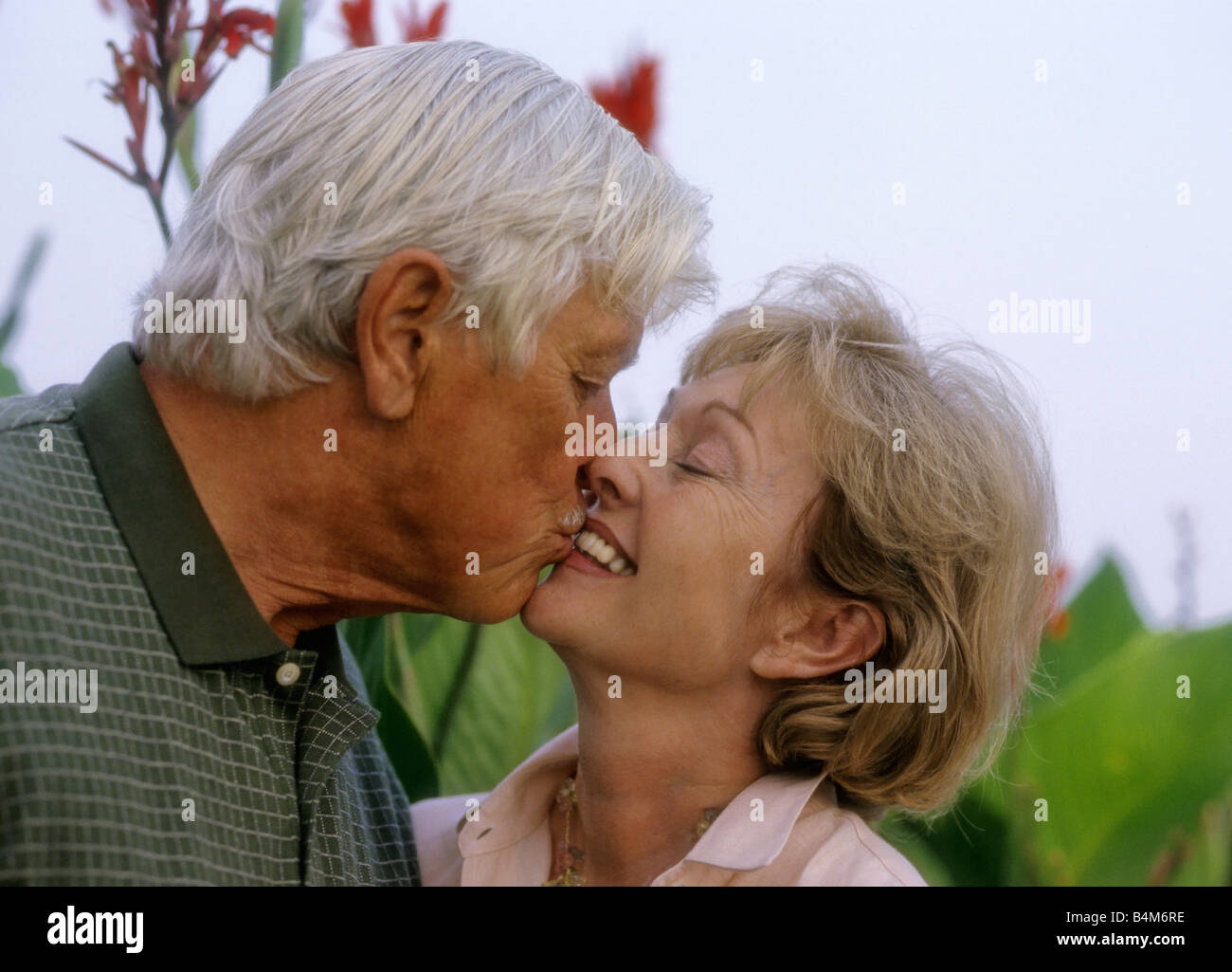 Älteres Paar küssen park Stockfoto