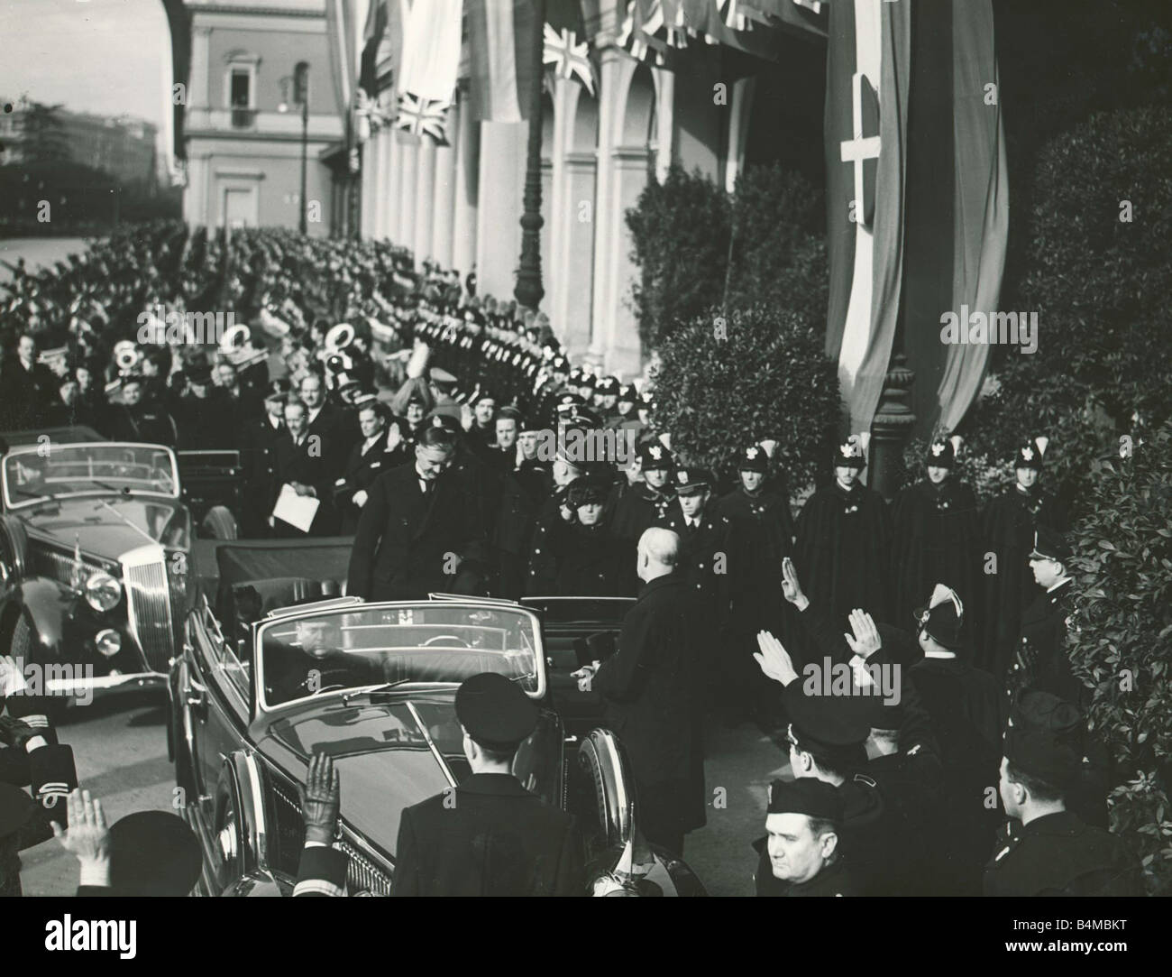 Neville Chamberlain kommt bei der Fuehrerhaus München für die 4 Power Pakt-Konferenz mit Adolf Hitler Monsieur Deladier und Signor Mussolini, wo die Vertreter der vier Mächte gesucht Vereinbarung über die Tschechische, Frage der Tschechischen s waren nicht vertreten unser Bild zeigt Neville Chamberlain Ankunft in die Fuehrerhaus gegeben den Hitlergruß warten Offiziere Oktober 1938 Zweiter Weltkrieg Mirrorpix Stockfoto