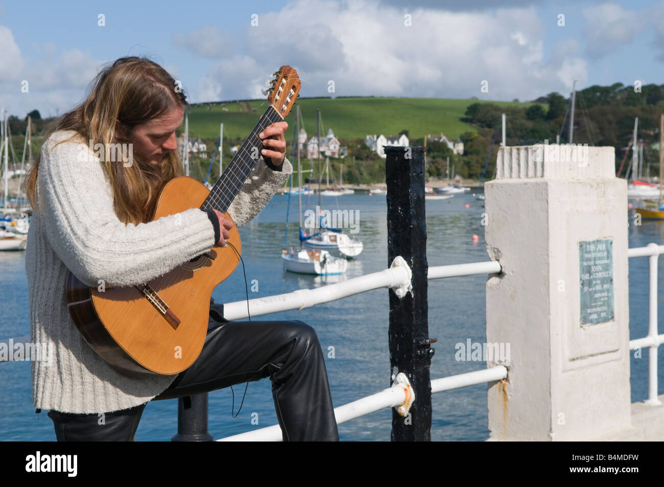 Ein Straßenmusikant spielt seine Gitarre auf dem Pier bei Falmouth UK Stockfoto