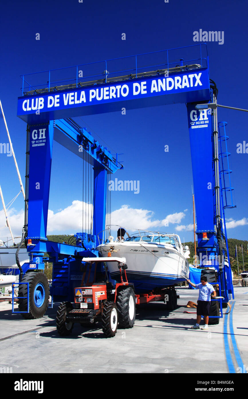 Ein Luxus-Cruiser geschleppt von einem roten Traktor in ein blaues Boot craane Stockfoto