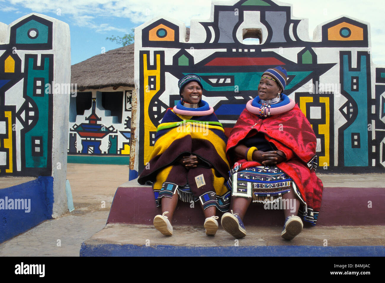 Südafrika. Mapoch Ndebele Dorf. traditionelle Wandmalereien Frauen mit traditioneller Kleidung und Dekoration Stockfoto