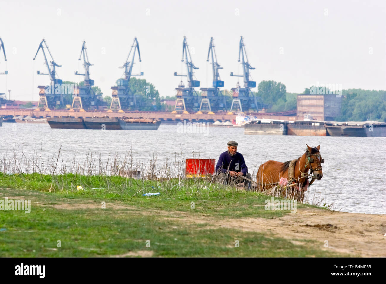 Ein Mann auf Horsecart vor riesigen Hafen in Galati, Rumänien. Galati ist die Stadt, das die Stelle markiert wo Donau-Fluss-Delta Stockfoto