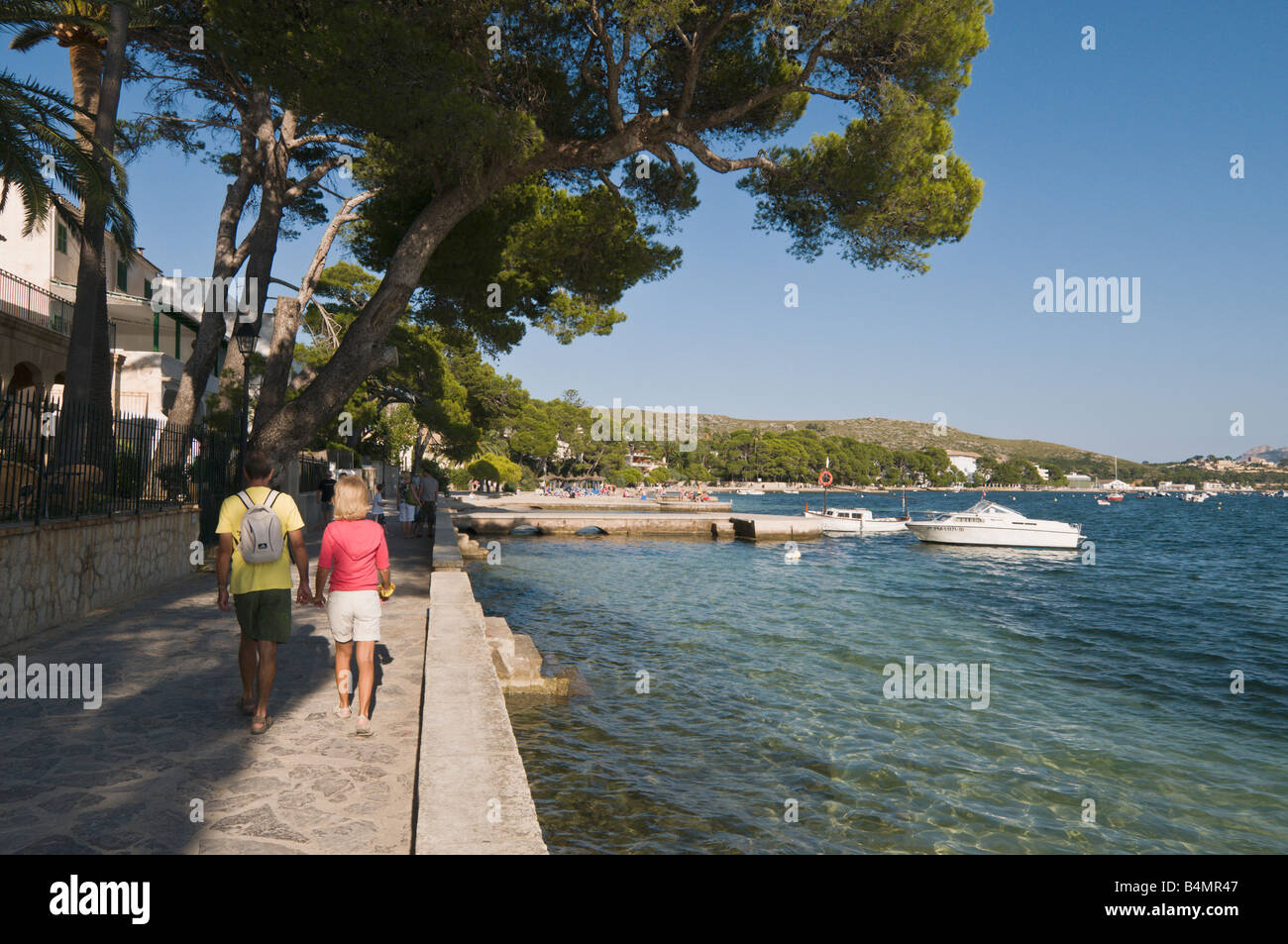 Touristen zu Fuß entlang der Pine Walk am Hafen von Pollensa, Mallorca, Spanien Stockfoto