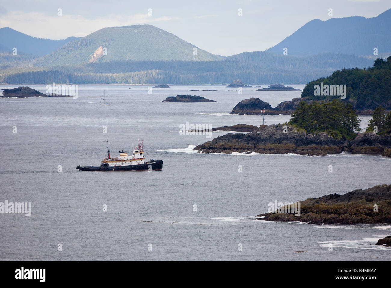 Ein Schlepper manövriert zwischen den felsigen Küsten in den Gewässern in der Nähe von Sitka Alaska Stockfoto