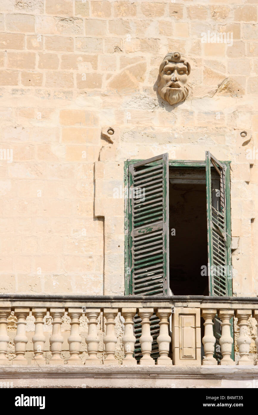 Alte verriegelt Türen, die Kreditvergabe an Balkon mit gruseligen steinernen Gesicht. Stockfoto