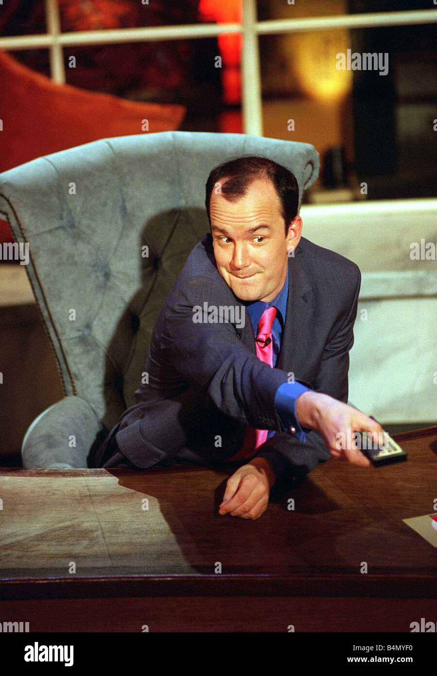 Jack Docherty sitzt im Stuhl linke Hand auf Schreibtisch rechts drücken der TV-Fernbedienung während Show auf Channel 5. April 1997 Stockfoto