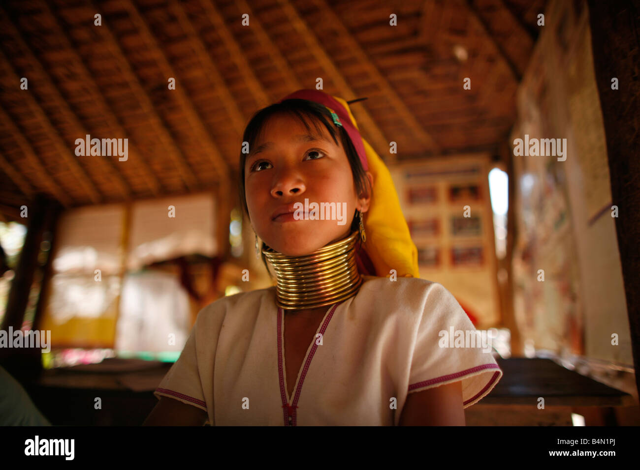 Ein Longneck-Mädchen in der Schule, die etwa 300 birmanischen Flüchtlinge in Thailand Mitglieder der indigenen Gruppe bekannt als die Longnecks die größte der drei Dörfer sind, wo die Longnecks Leben, heißt Nai Soi gelegen in der Nähe von Mae Hong Son Stadt Longnecks Verschleiß Metall-Ringe auf den Hals des Schlüsselbeins getan und verlängern den Hals sind sie eine touristische, die Attraktion Touristen besuchen Nai Soi zu fotografieren die Longnecks und kaufen ihre Handarbeiten, die die Dörfer kritisiert werden von Menschenrechtsorganisationen wie menschliche zoos Stockfoto