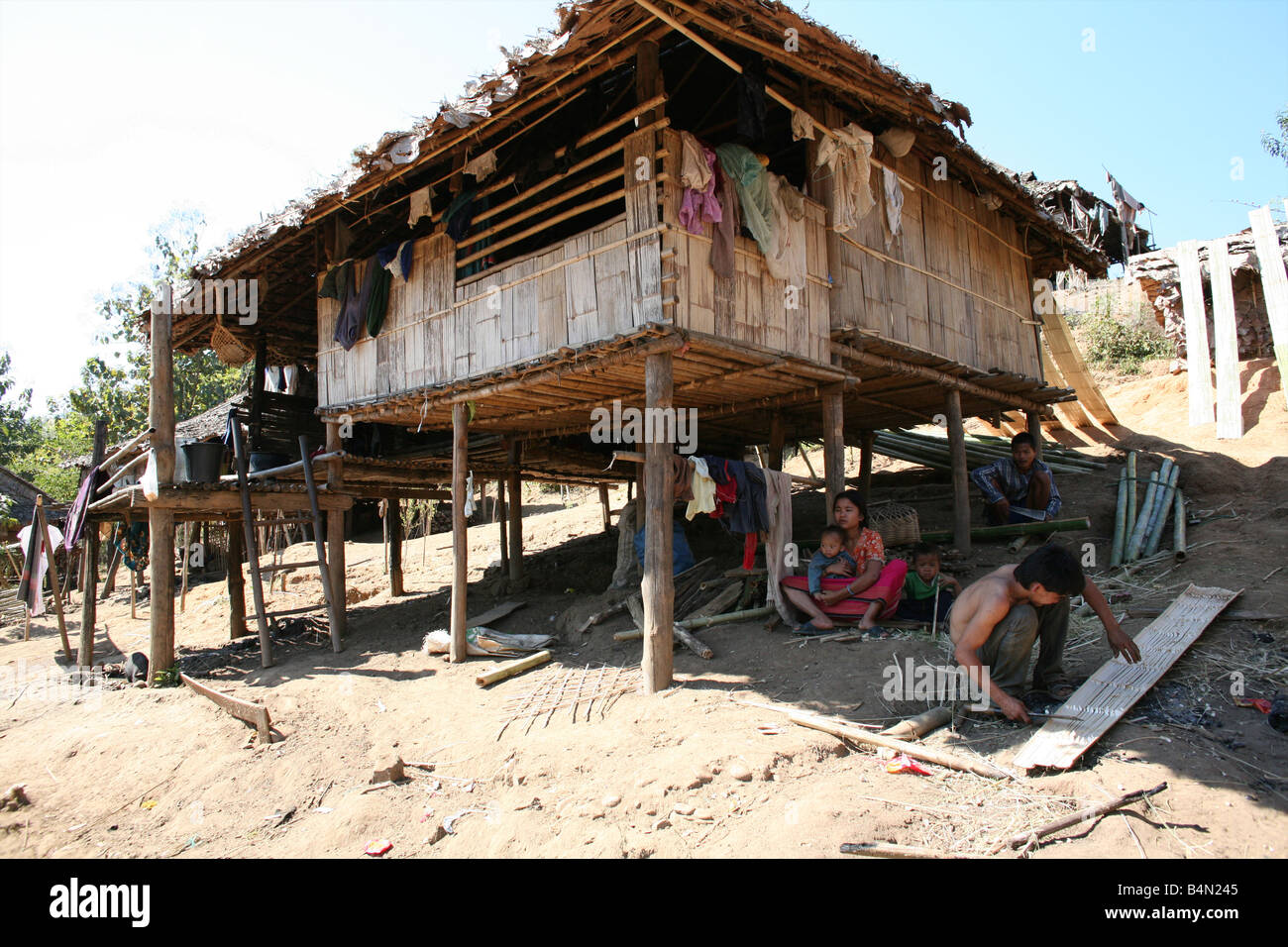 Eine burmesische Familie sitzt im Schatten von ihrer Hütte in der vertriebenen Personen Camp nahe der Grenze zu Thailand In Myanmar Burma, Tausende von Menschen in der Nähe von der Grenze als Folge der Unterdrückung in ihrem Heimatland um 200 birmanischen niedergelassen haben, die Vertriebenen in La pro Her auf ein Dorf niedergelassen haben, die burmesische Seite der Grenze zu Thailand in der Nähe der thailändischen Stadt von Mae Sot sie verweigern die Grenze zu überqueren, weil sie wollen, bleiben Ihre Heimat unterstützen diese Flüchtlinge die Rebellenbewegung namens Straflosigkeit Karen National Liberation Army betreibt in östlichen Birma Jan 2007 Stockfoto