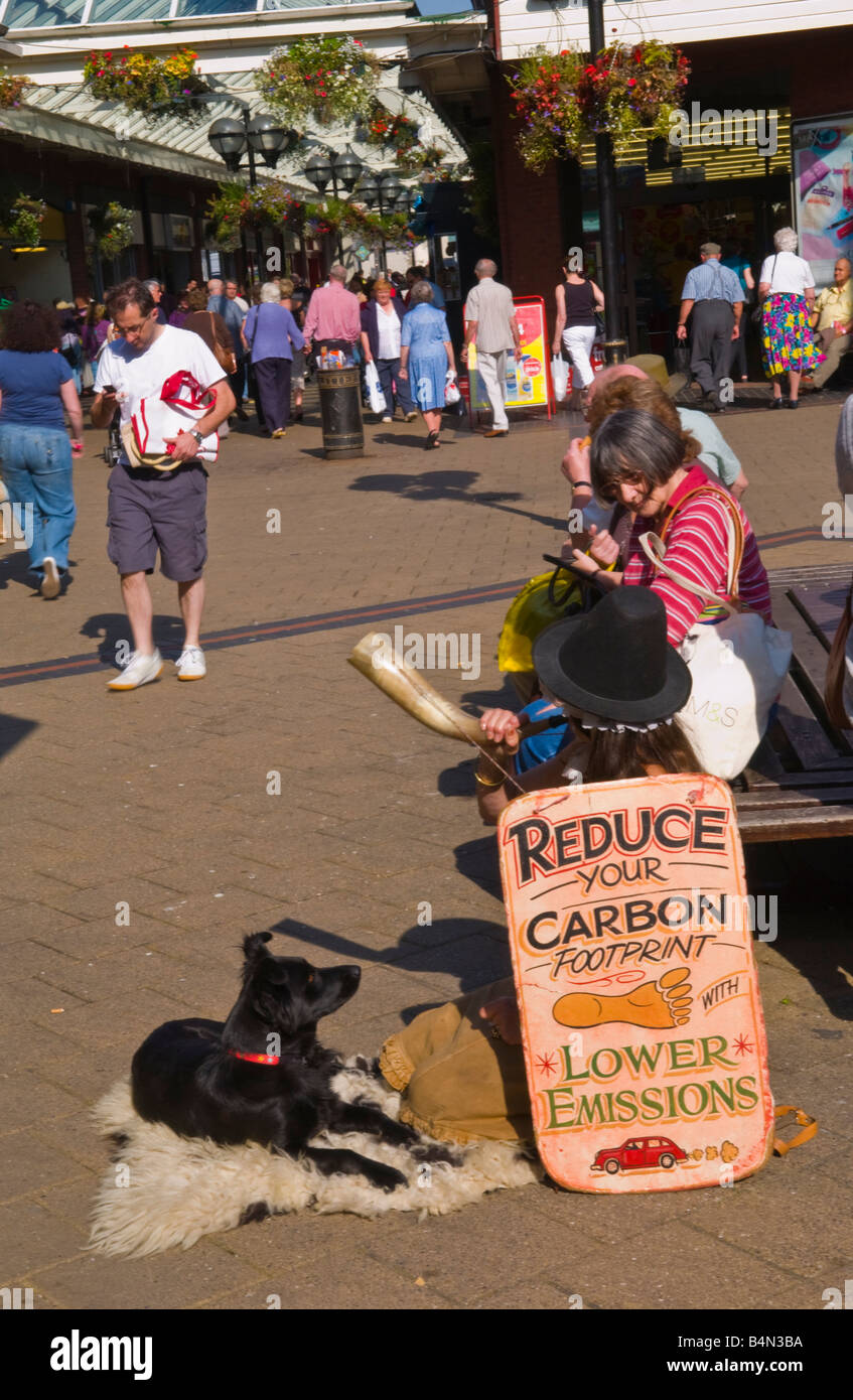 Frau mit Schild anmelden Shopping Centre UK reduzieren YOUR CARBON FOOTPRINT mit weniger Emissionen Stockfoto