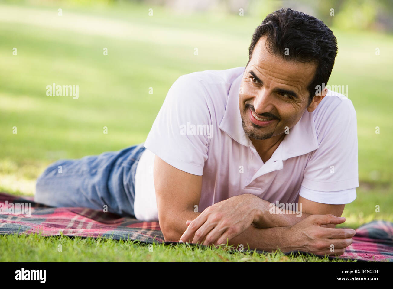 Mann liegen im Freien im Park lächelnd (Tiefenschärfe) Stockfoto