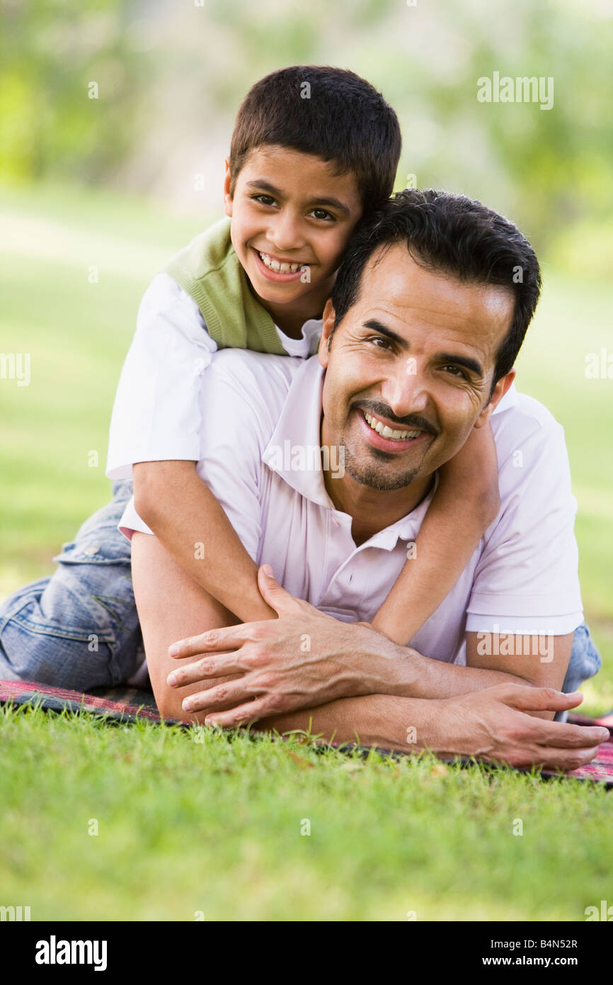 Vater und Sohn im Freien im Park umarmt und lächelnd (Tiefenschärfe) Stockfoto