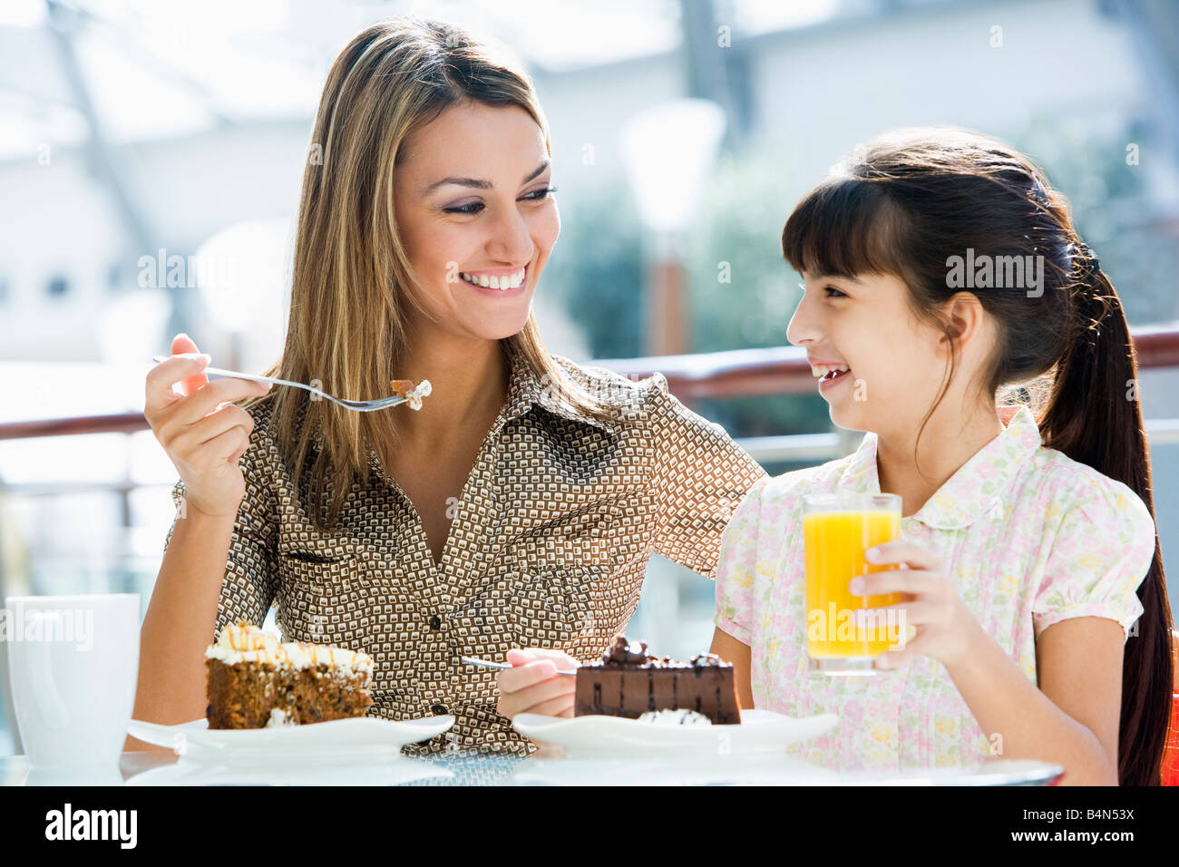 Mutter im Restaurant mit Tochter Essen Dessert und lächelnd (Tiefenschärfe) Stockfoto