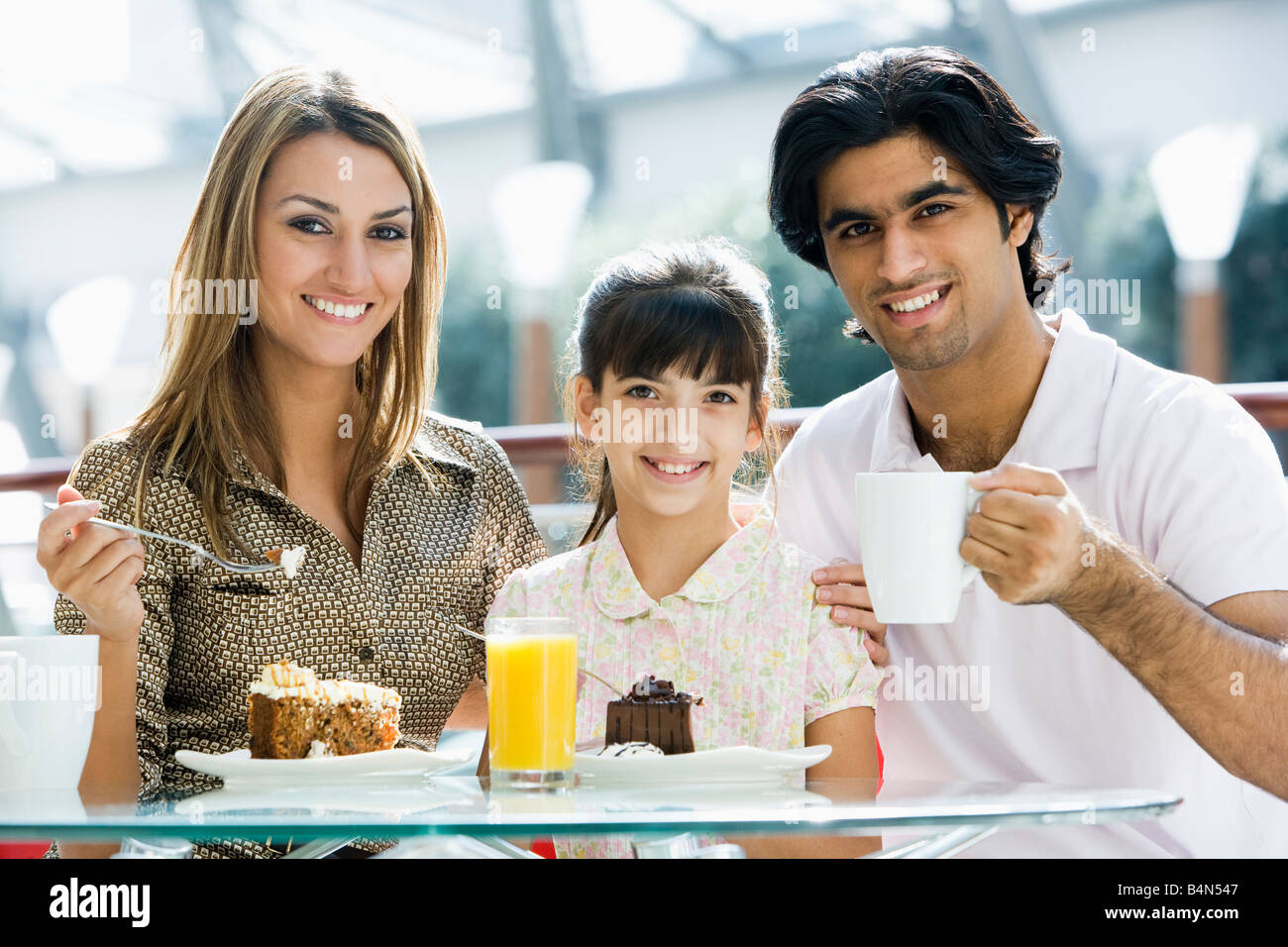 Familie im Restaurant Essen Dessert und lächelnd (Tiefenschärfe) Stockfoto