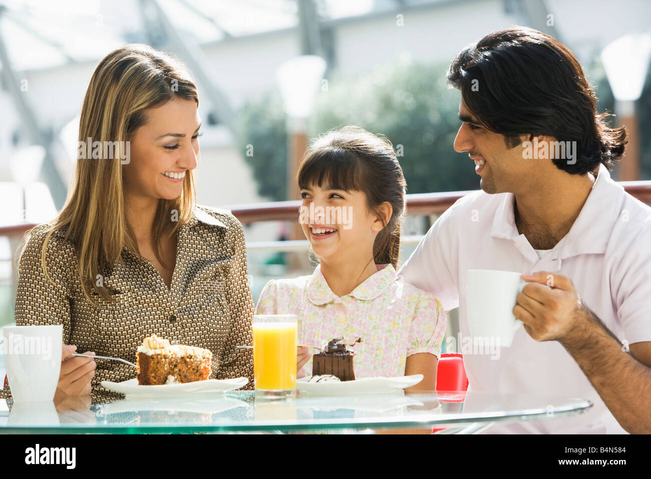 Familie im Restaurant Essen Dessert und lächelnd (Tiefenschärfe) Stockfoto
