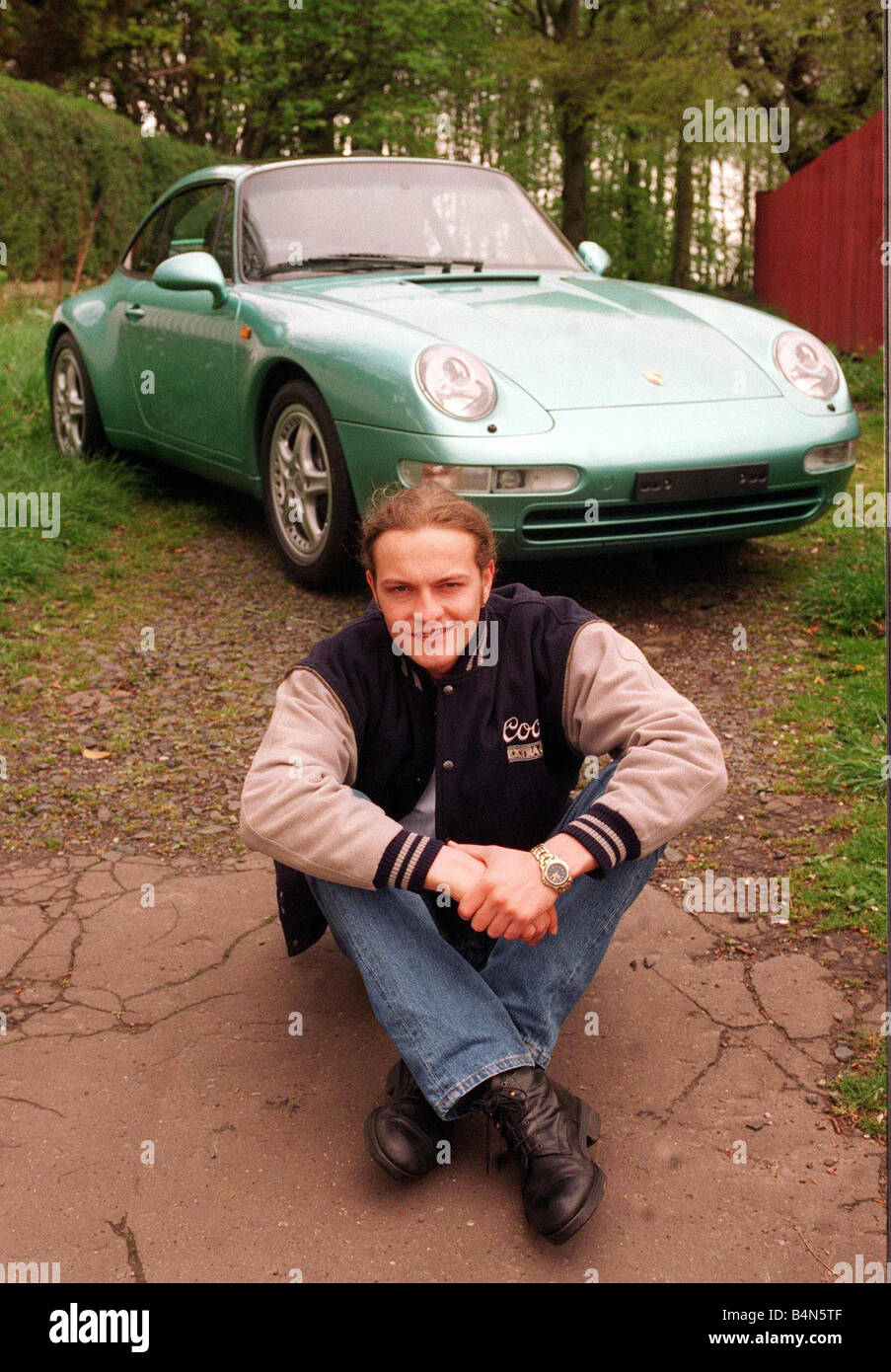 Schauspieler Simon Weir stellt mit dem Porsche Targa 911 Auto Mai 1997 am Boden sitzen Stockfoto