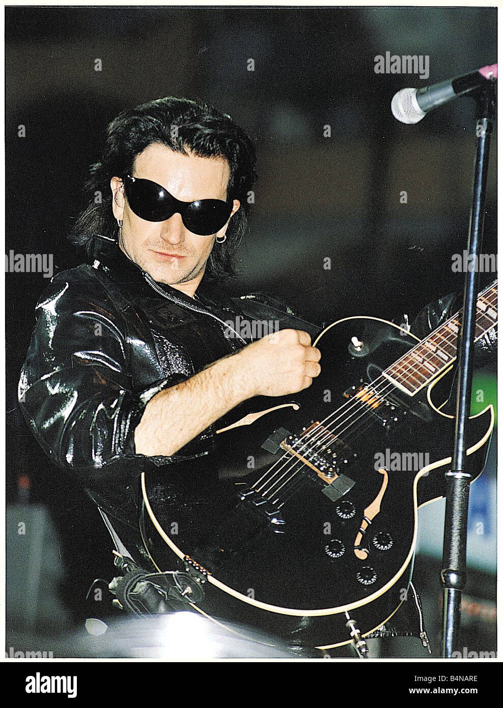 Bono lead-Sänger mit Popgruppe U2 trägt schwarze Leder circa 1994 Stockfoto
