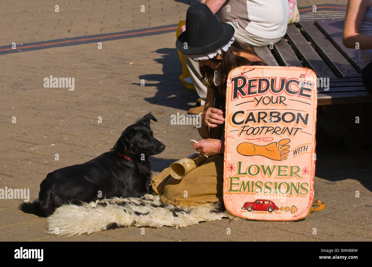 Frau mit Schild anmelden Shopping Centre UK reduzieren YOUR CARBON FOOTPRINT mit weniger Emissionen Stockfoto