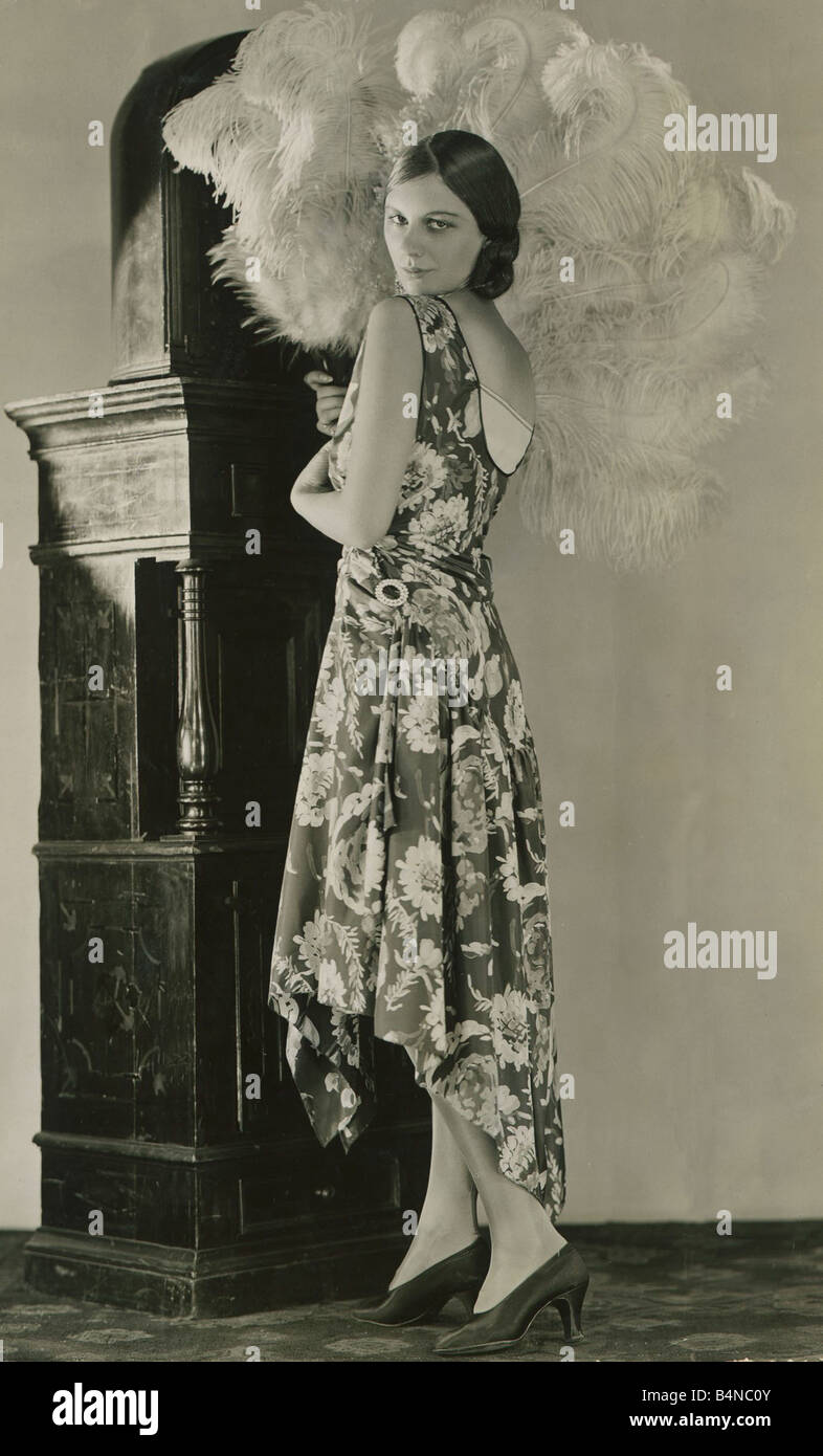 Mode der 1920er Jahre September 1928 neue weiche Taft Abendkleid in dunkelblau mit Fett Desgn in hellen Farben bedruckt und zeigen die modischen Pfau Silhouette Barock Stockfoto