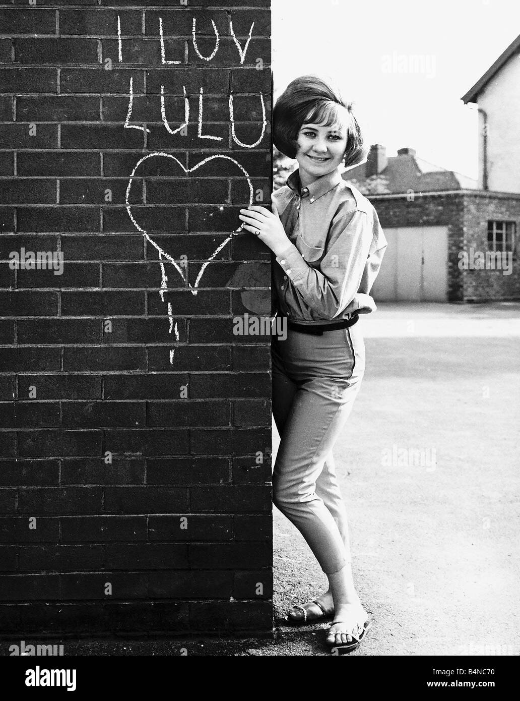 LuLu-Pop-Sängerin steht neben der Mauer im Jahr 1964 Stockfoto