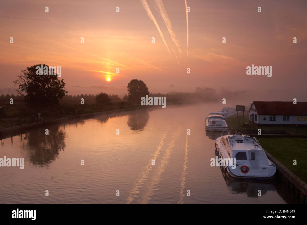 Der Fluss Bure bei Sonnenaufgang an einem nebligen Morgen angesehen von Acle Brücke auf den Norfolk Broads Stockfoto