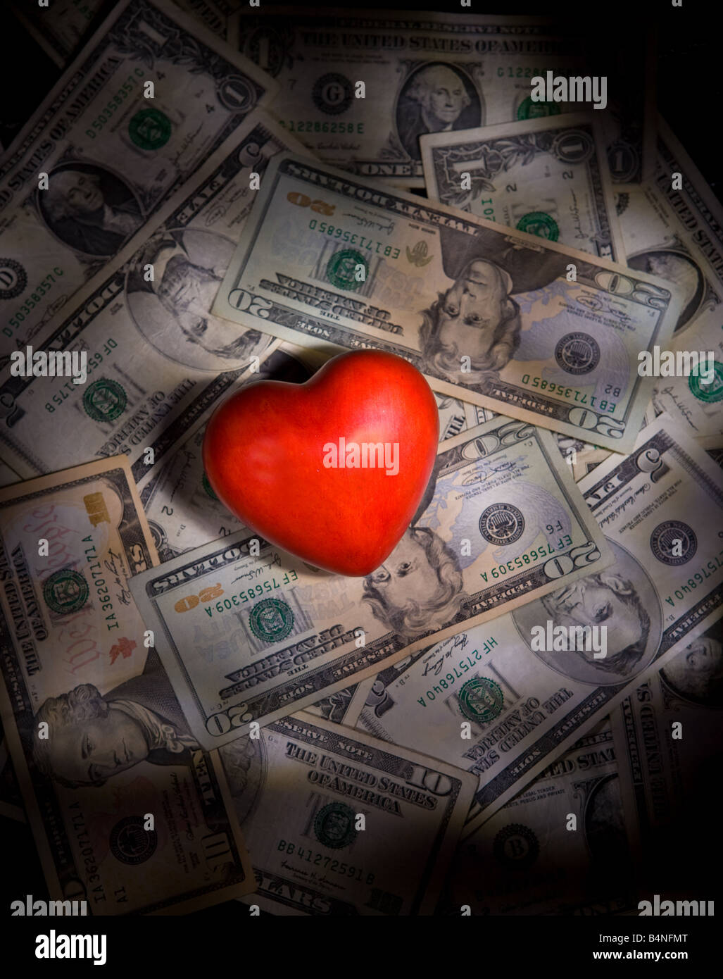 Ein Herz mit uns Geld Foto Illustration mit dramatischen Licht. Investieren mit Ihrem Herzen-Konzept. Nächstenliebe und Philanthropie. Stockfoto