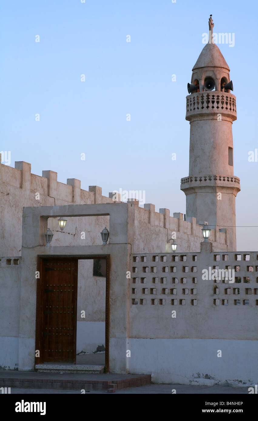 Eine alte Moschee in Katar Arabien gegenüber das Heritage Village in Doha mit Lampen beleuchtet zum Zeitpunkt für die Abend-Aufruf zum Gebet Stockfoto