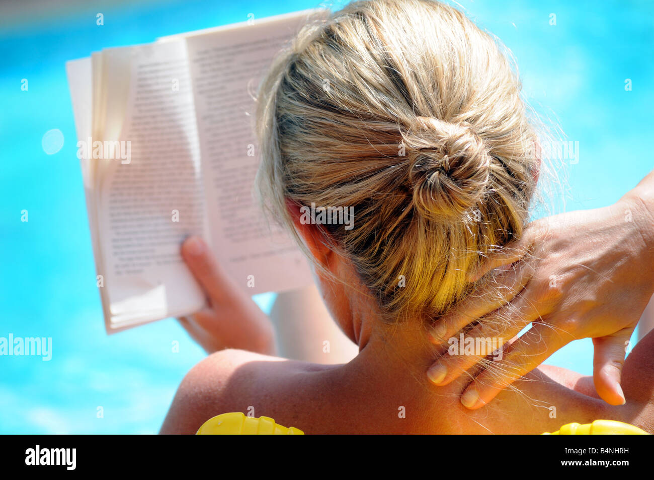 Royalty free Foto Frau sitzen, lesen, entspannen und Swimming Pool in der Sonne bräunen, im Urlaub. Stockfoto