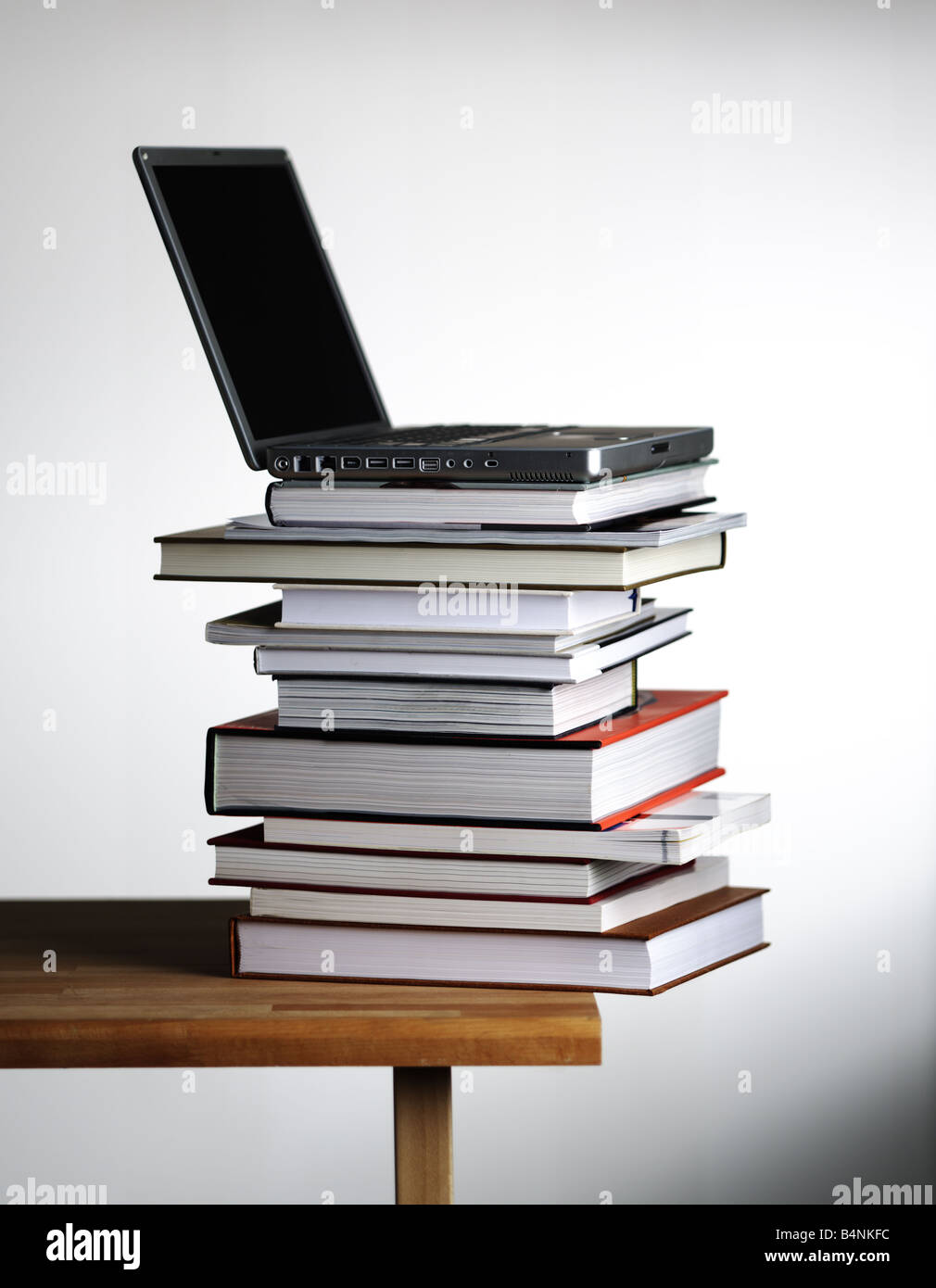 Offenen Laptop-Computer auf Stapel Bücher auf weißen Rand Tabellenhintergrund Stockfoto