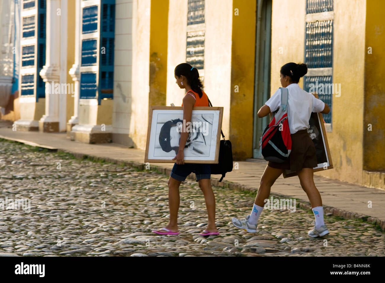 Schulmädchen auf der Plaza Mayor mit Fotos von Che Guevara und Fidel Castro Stockfoto