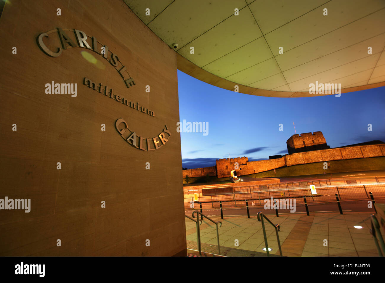 City of Carlisle, England. Nachtansicht des Eingangs Tullie House Museum & Art Gallery mit Carlisle Castle im Hintergrund. Stockfoto