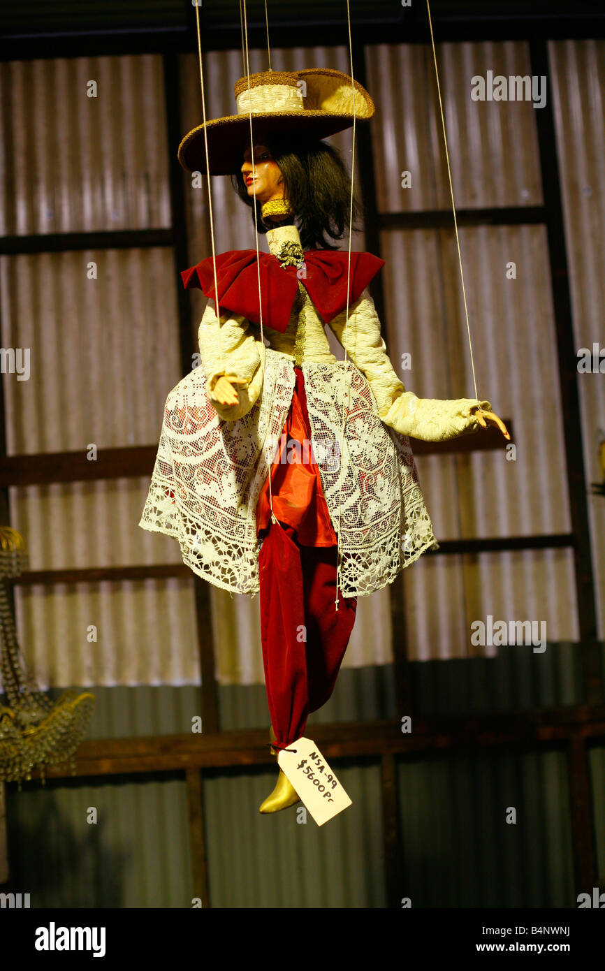 Eine schöne Puppe hängt unter Kronleuchtern zu verkaufen in einem Second Hand Laden Stockfoto