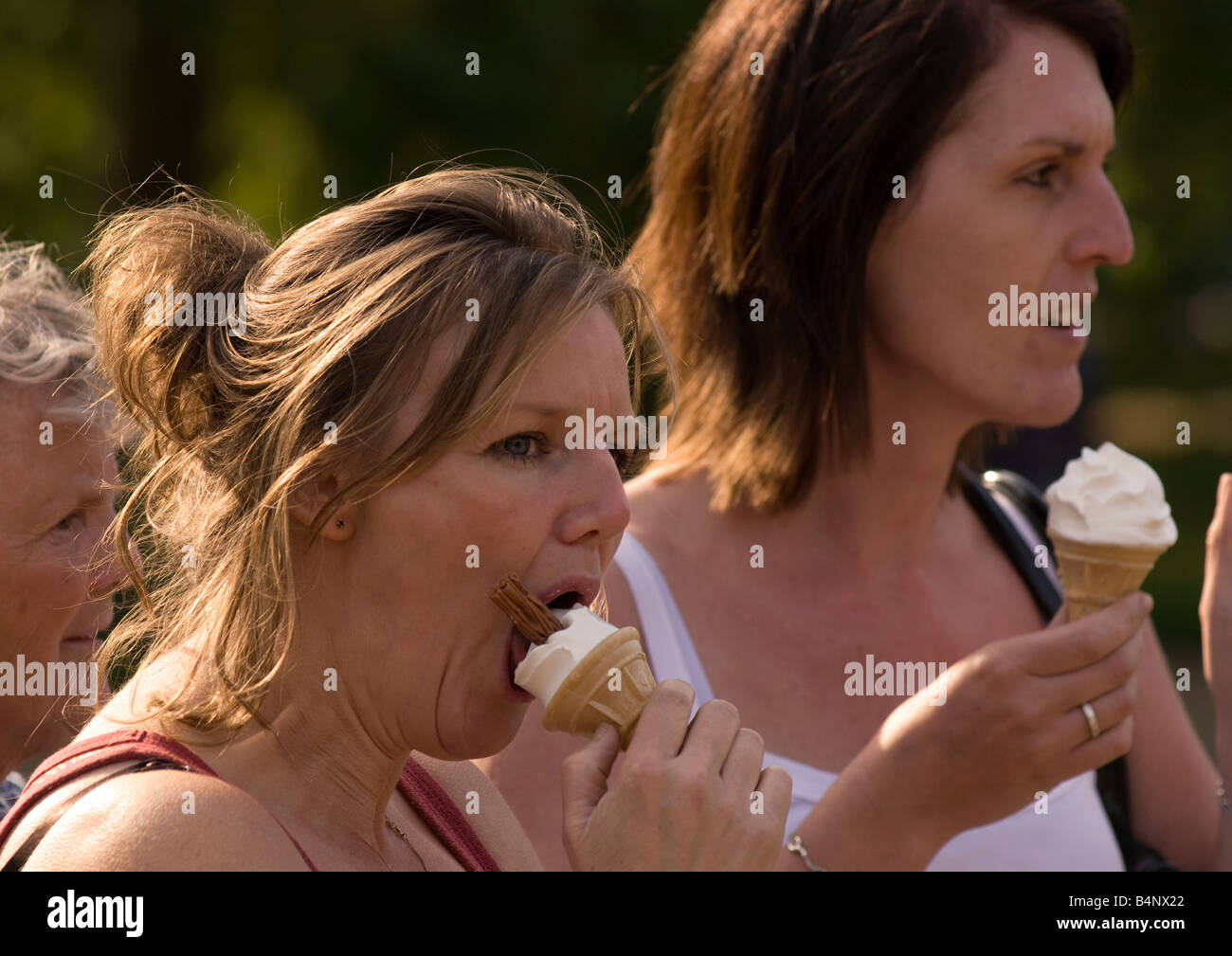 Frauen essen Eiscreme-Kegel im Hyde Park, London, UK. Stockfoto