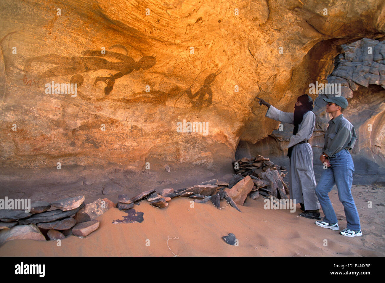 Algerien Djanet NP Tassili n Ajjer UNESCO-Welterbestätte Prähistorische Felsmalereien Mann der Tuareg Stamm und touristischen Sahara Stockfoto