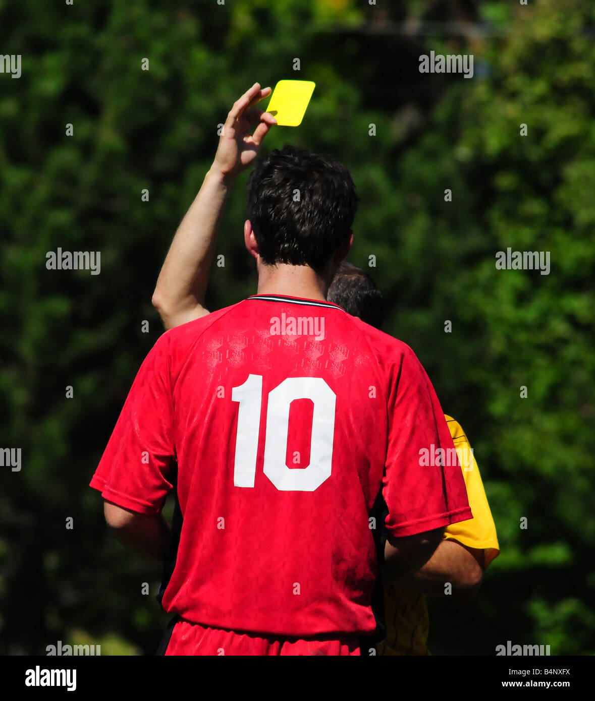 Ein Fußball- oder Fußball Spieler erhält eine gelbe Karte für einen Elfmeter in einem Spiel oder match Stockfoto Ein Fußball- oder Fußball Spieler erhält eine gelbe Karte für einen Elfmeter in einem Spiel oder match Stockfoto