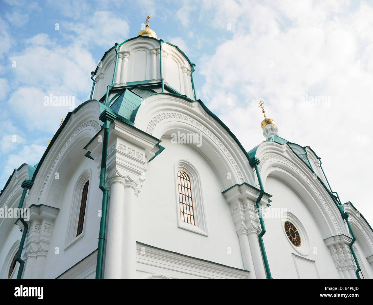 Weiße Wände der orthodoxen Kathedrale mit Cyan Kuppeln gegen blauen Wolkenhimmel, Svyatogorskaya Svyato-Uspenskaja Lawra Stockfoto