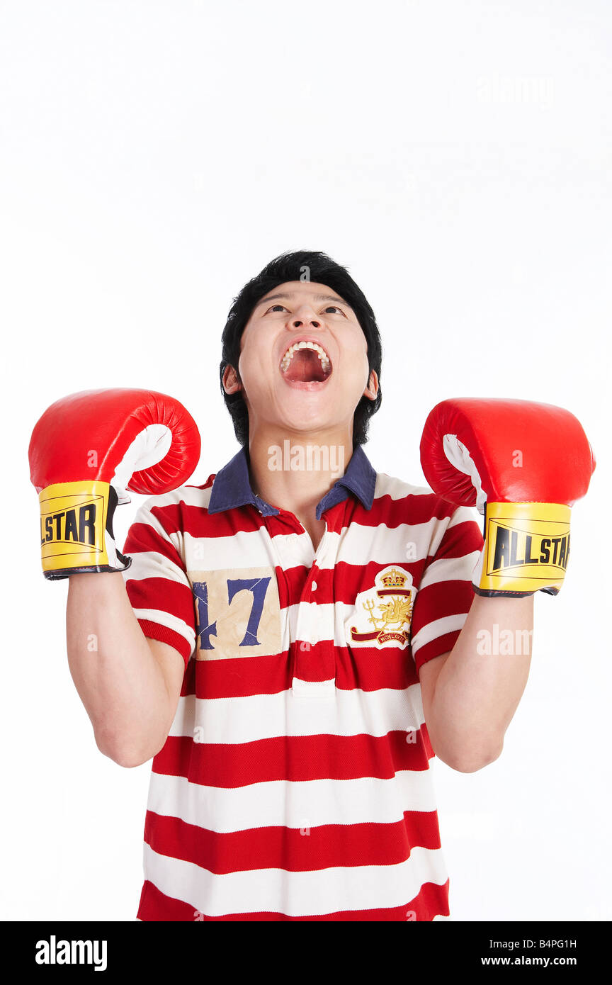 Junger Mann tragen Boxhandschuhe und schreien Stockfoto