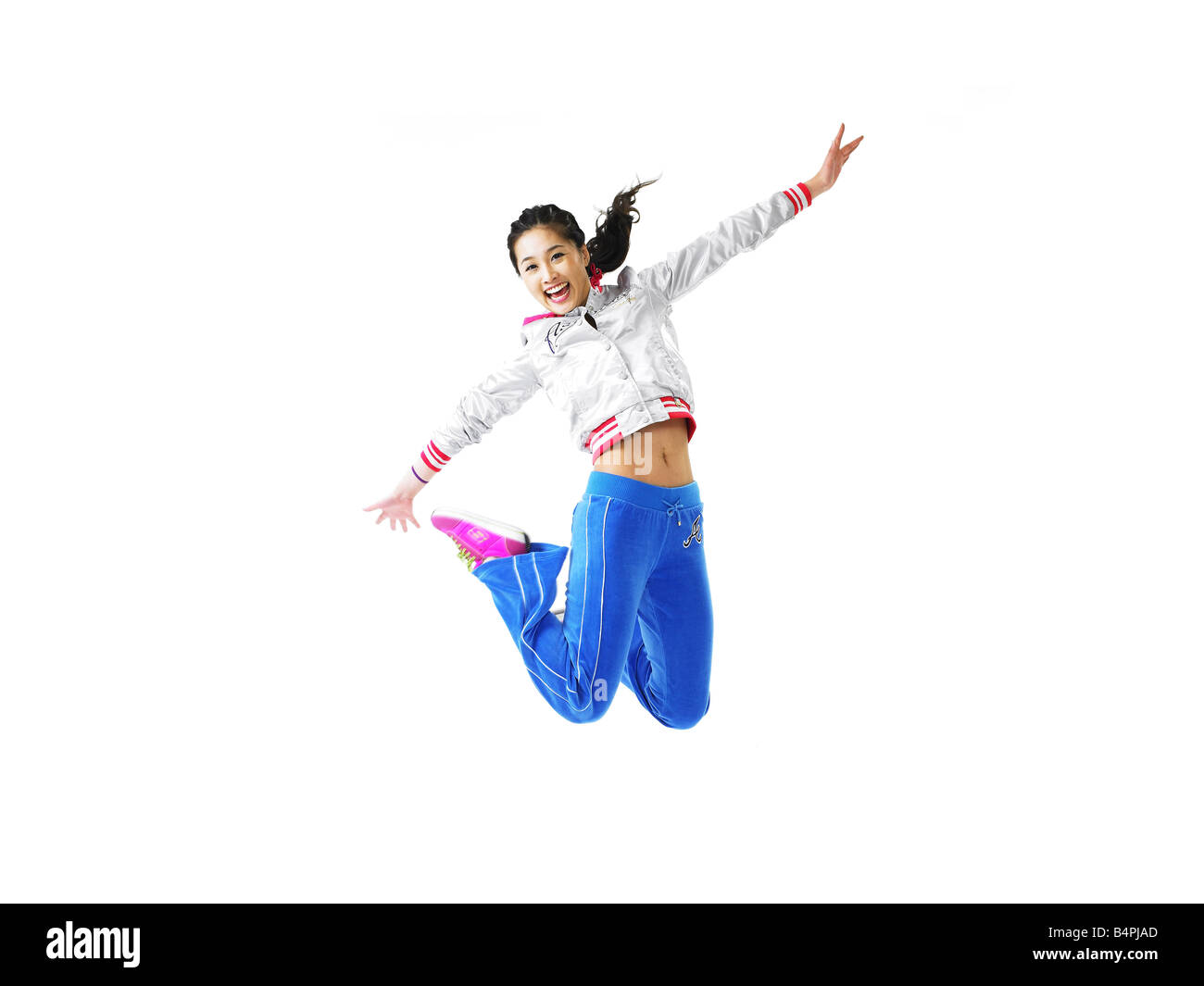 Junge Frau springt in die Luft, Lächeln, Porträt Stockfoto