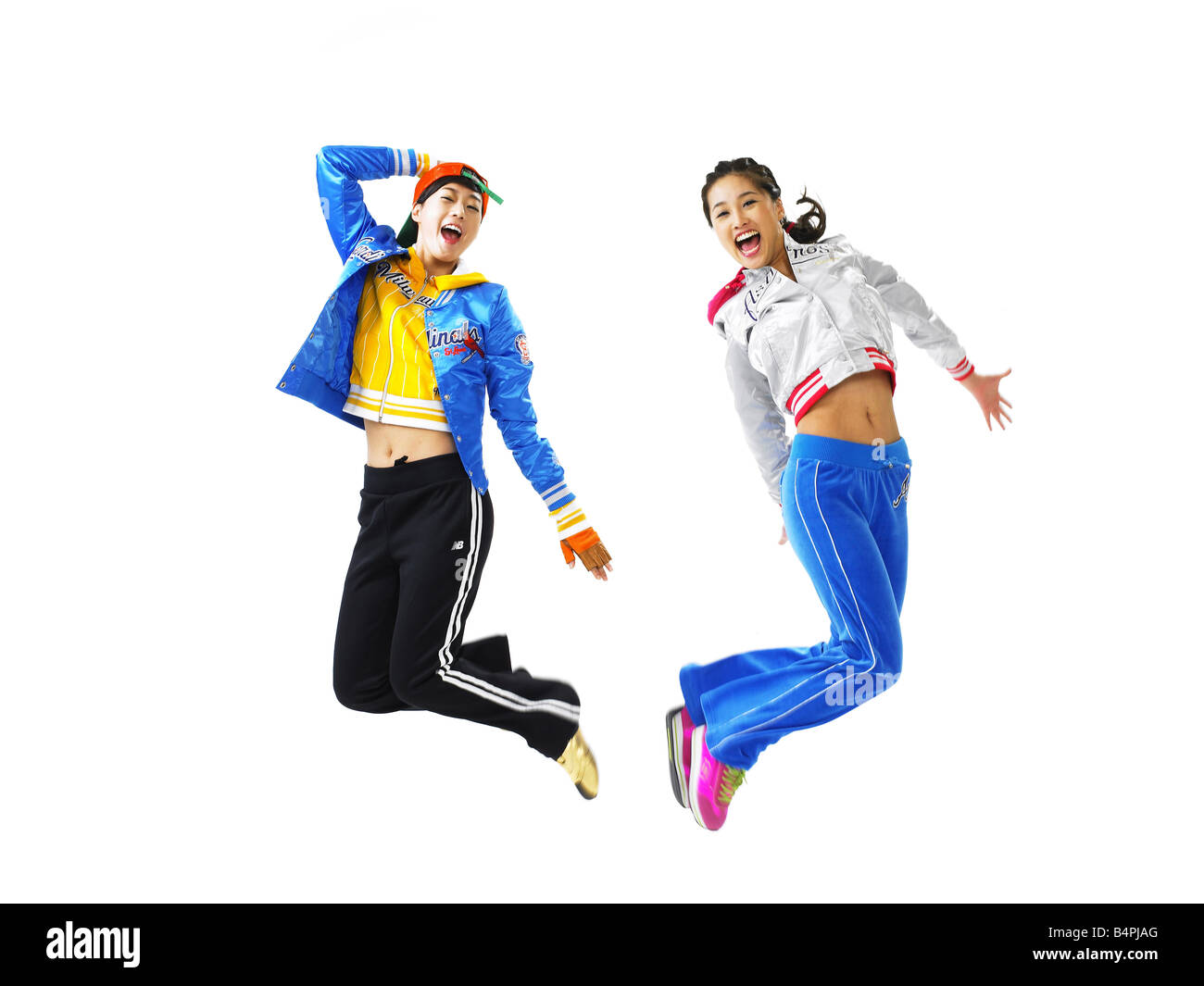 Zwei junge Frauen, die einen Sprung in der Luft, Lächeln, Porträt Stockfoto