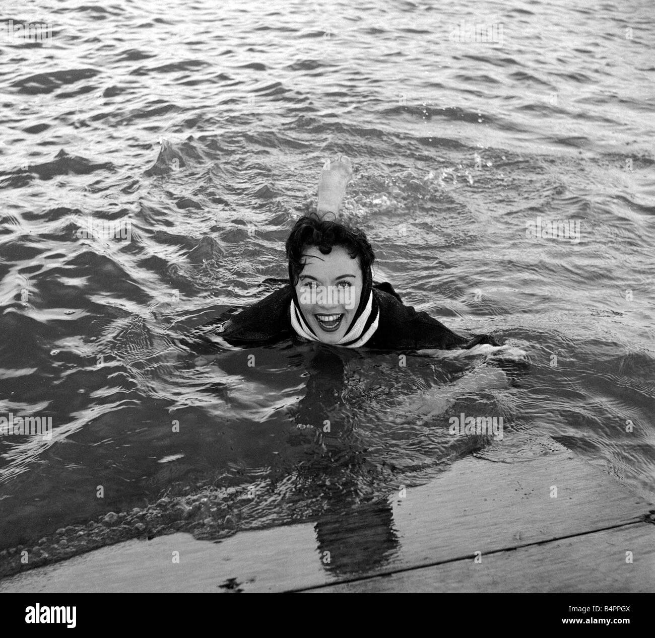 Grace O Connor Sopran Kabarett und TV Sängerin ist wahnsinnig scharf auf Wasserski Grace trägt eine Alpine Pullover und einen Regenschirm um Regen aus ihrem Haar zu halten, sie war glücklich über das Wasser beschleunigt, aber alle Wasserskifahrer nehmen einen Wäschetrockner manchmal Oktober 1957 Stockfoto