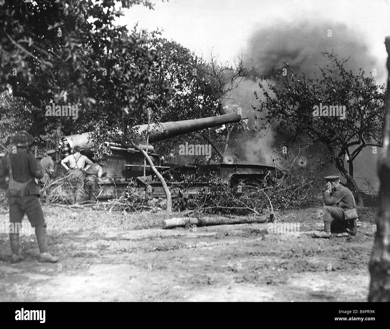 Britische Artillerie bombardieren feindliche Stellungen 1916 während dem Vormarsch an der Westfront im ersten Weltkrieg ein kniender Soldat hält seine Ohren, wie die Waffe abgefeuert wird Stockfoto
