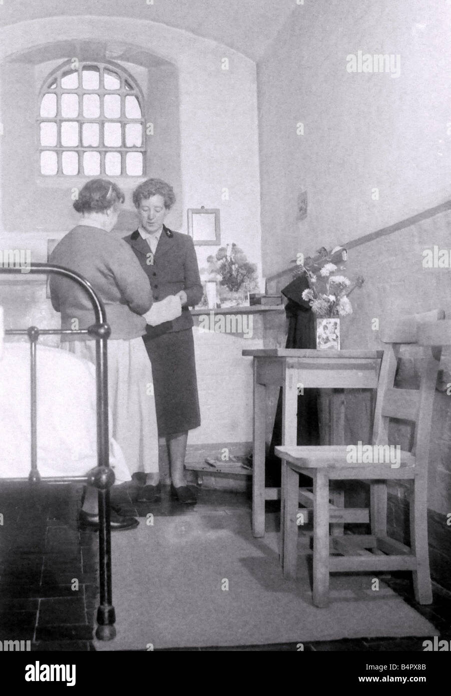 Winson Green Gefängnis Gefängnis CEO Miss Croom untersucht eine Kleidungsstück, dass einer der Insassen gestrickt hat in ihrer Zelle weibliche Häftlinge ihre Zellen so viel wie zu Hause wie möglich zu machen und stolz hält sie sauber und ordentlich 1958 Stockfoto