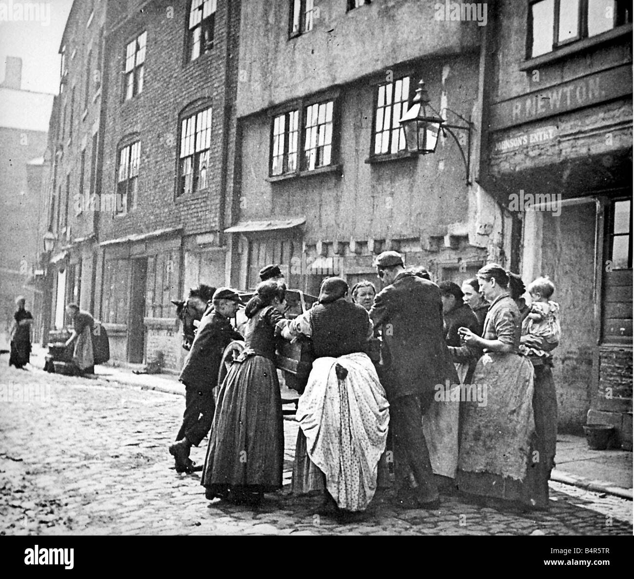 Eine Szene von Leben der Arbeiterklasse, die Frauen um den Pferd gezeichneten Wagen von einem Straßenhändler versammeln Stockfoto