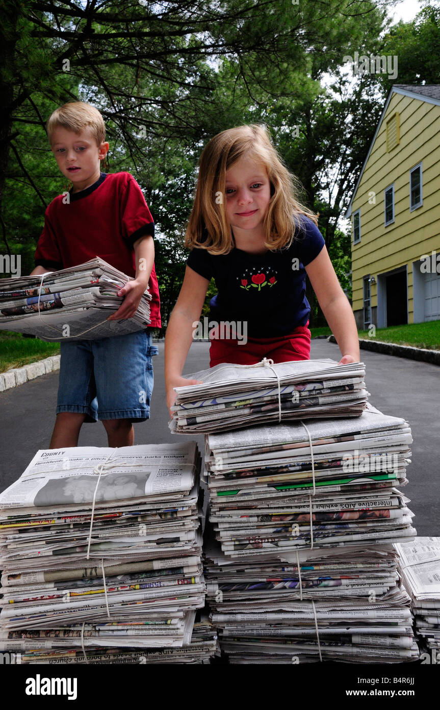 Kinder Stapeln Zeitungen für Papier-recycling Stockfoto