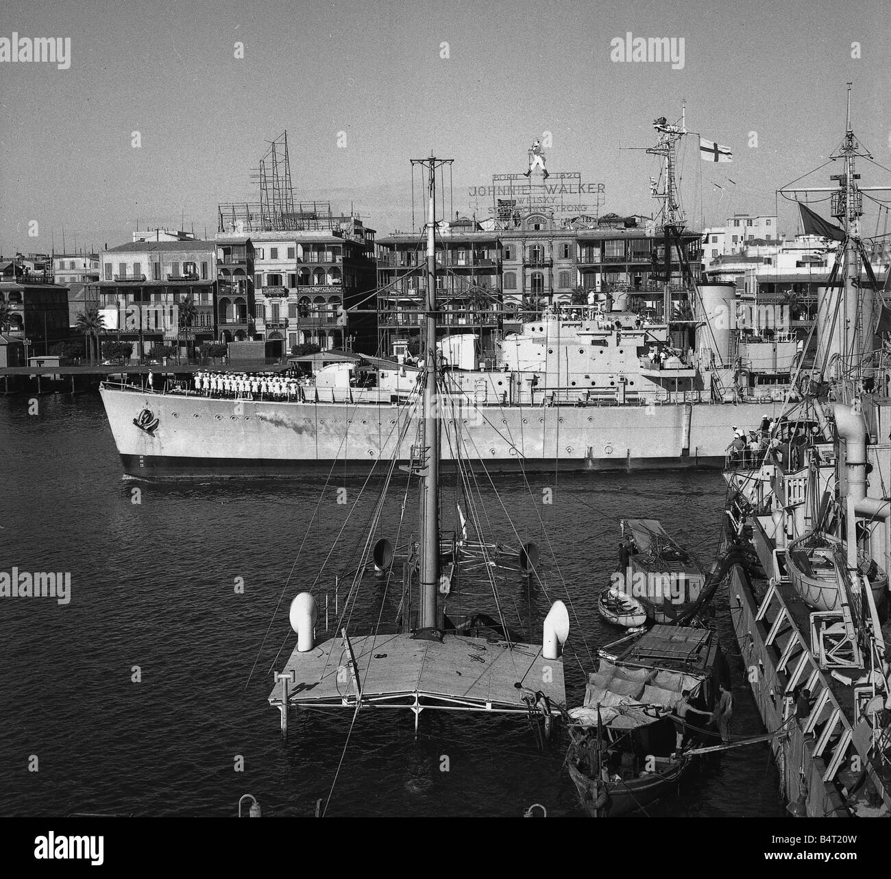 Suez Krise 1956 The 4000 Tonnen Minenleger Manxman wird das erste Schiff, den Kanal zu segeln, nachdem ein Kanal gelöscht wurde, so dass Schiffe von bis zu 10000 Tonnen im Vordergrund eingeben, den versunkene Wrack von einem ägyptischen Saugbagger gesehen werden kann Stockfoto