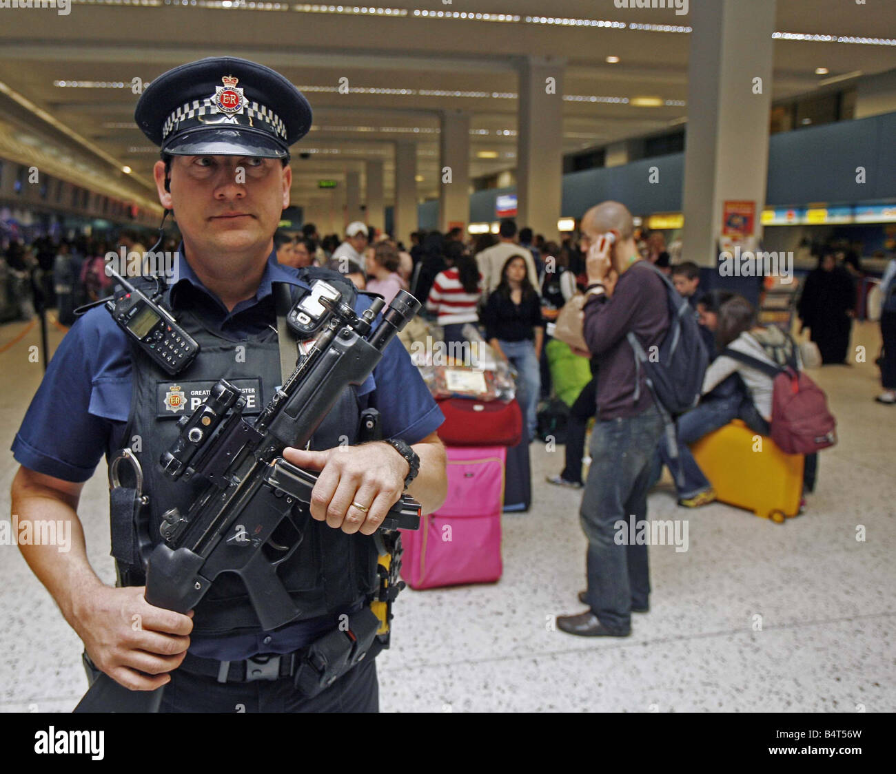 Ein bewaffneter Polizist patrouilliert Manchester Airport nach anti-Terror-Einheiten der Metropolitian Polizei und MI5 vereitelt ein Terroranschlags auf mehrere Flugzeuge im Flug zwischen den Vereinigten Staaten und das Vereinigte Königreich mit Sprengstoff in die Luft sprengen in der hand Gepäck August 2006 geschmuggelt Stockfoto