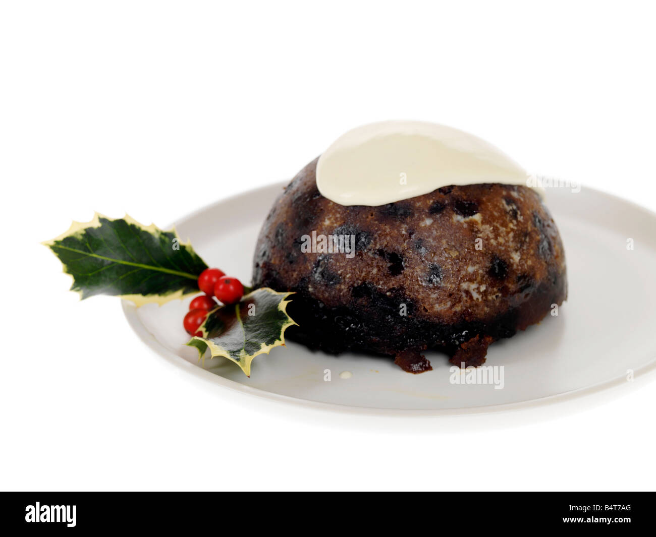 Eine traditionelle Weihnachtspudding mit Holly und Rote Beere traditionellen Dekorationen und gekrönt mit Brandy Sauce auf Teller serviert gegen Weiße Stockfoto